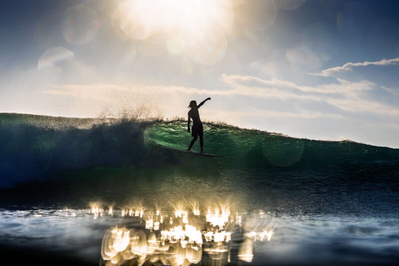 A silhouetted surfer rides a wave at sunset, with sunlight and lens flares reflecting on the water and in the sky, creating a dramatic and vibrant scene.