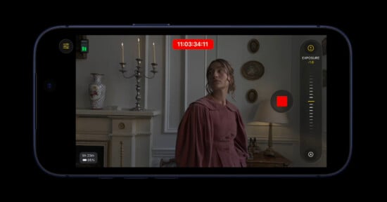 A smartphone screen displays a video recording interface with a woman in a historic-style dress standing near a fireplace, decorative vases, and candlesticks in a vintage room. Exposure settings and a red record button are visible.