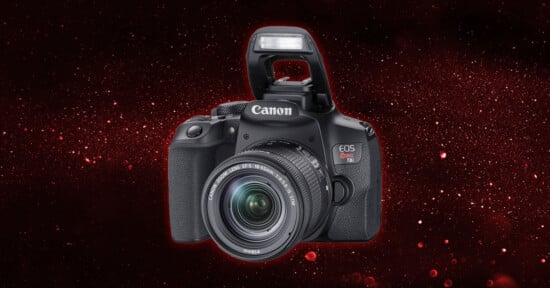 A Canon EOS Rebel T100 DSLR camera with its flash raised, set against a dark red, starry background.