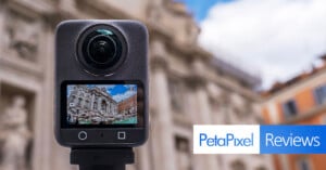 A 360-degree camera displays a photo of an ornate building on its screen, with the same building blurred in the background. The image includes the "PetaPixel Reviews" logo at the bottom right.