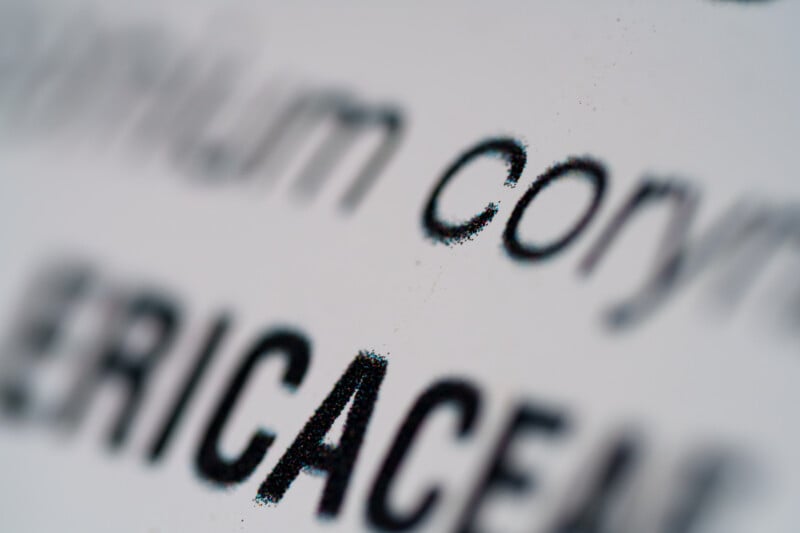 Close-up image of a printed page showing blurred black text on a white background, with the word “Cory” and part of the word “ERICACEAE” in focus.