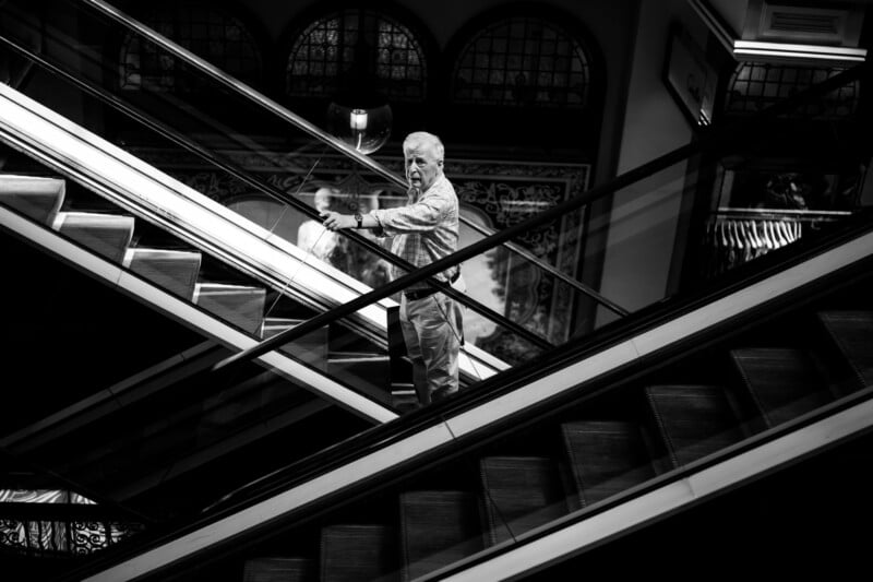 A man standing on an escalator.