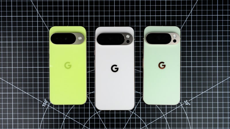 Three Google Pixel phones in different colors—light green, white, and pale mint—are displayed on a black grid cutting mat, showing their backs with camera bars and Google "G" logos.