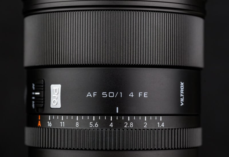 Close-up of a black Viltrox camera lens showing focus and aperture rings, labeled "AF 50/1 4 FE" with aperture values from 1.4 to 16, and a textured grip for adjustment.