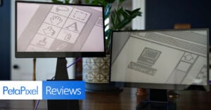 Two computer monitors displaying pixel art designs are placed on a wooden table, surrounded by greenery. The image is branded with "PetaPixel Reviews" in the bottom left corner, suggesting a tech or gadget review setting.