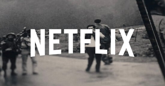 The word "NETFLIX" in bold white letters is superimposed over a blurred black-and-white photo of people walking outdoors.