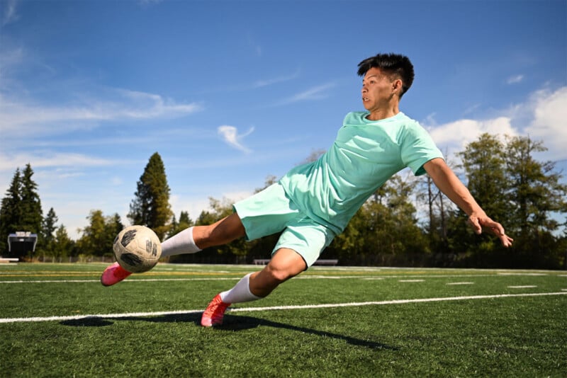 sports photo of an Asian man kicking a soccer ball, action photo