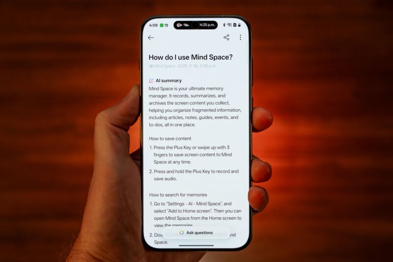 A hand holds a smartphone displaying instructions on how to use the Mind Space app, with text explaining features and steps. The background is out of focus and has a warm orange tone.