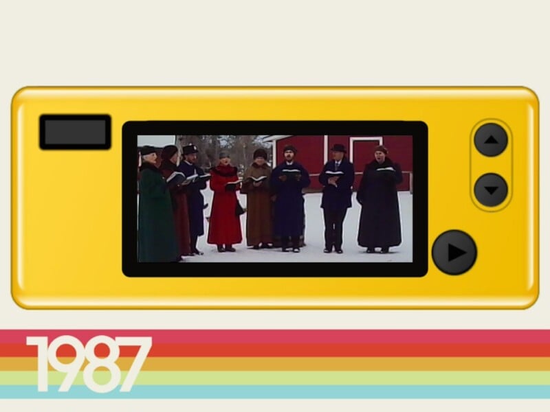 A group of people dressed in winter clothing sing outdoors in the snow, shown on a yellow retro TV screen graphic with “1987” and colorful stripes at the bottom.