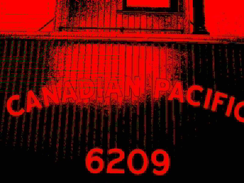 Red and black stylized image showing the words "CANADIAN PACIFIC" and the number "6209" on the side of a train car with vertical panel lines.