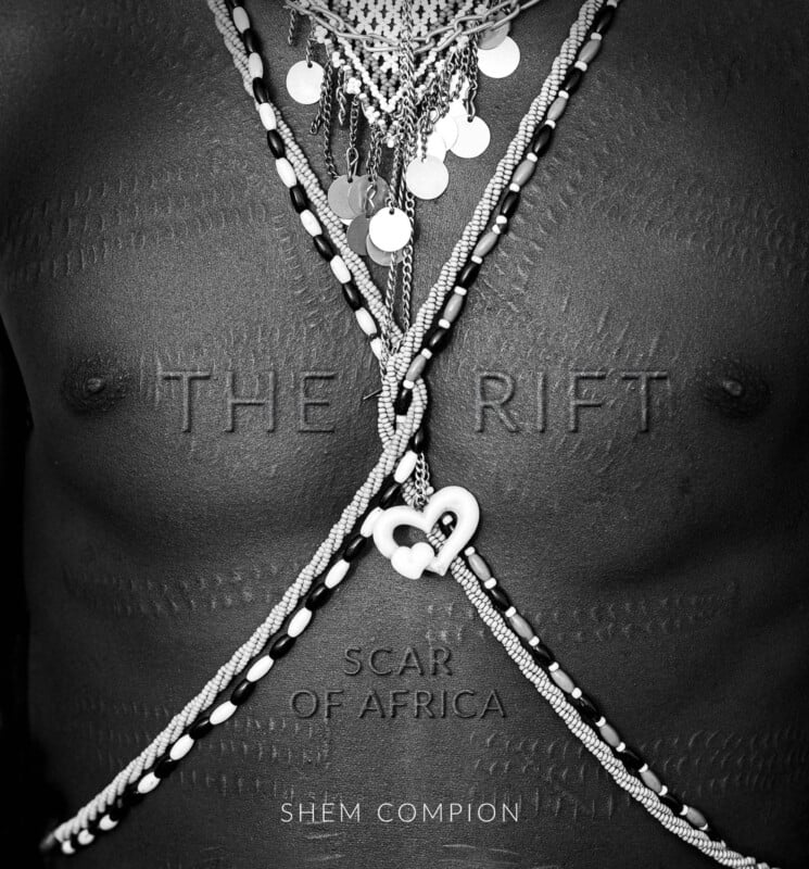 Black-and-white photo of a person's chest adorned with beaded necklaces and jewelry; intricate raised scarification marks are visible, with the words "THE RIFT SCAR OF AFRICA" and "SHEM COMPION" overlaid on the image.