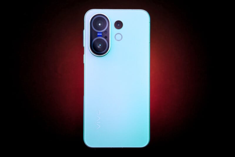 A light blue Vivo smartphone shown from the back, featuring two large camera lenses in the top left corner and a circular flash below them, against a dark background with a red glow.