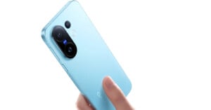 A hand holding a light blue Vivo smartphone, showing the back with dual camera lenses and a fingerprint sensor against a white background.