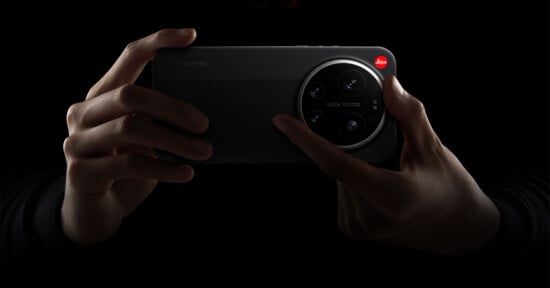 A person holds a Xiaomi smartphone with a large Leica-branded camera module, highlighted against a dark background.
